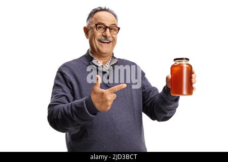 Reifer Mann hält ein Honigglas und lächelt isoliert auf weißem Hintergrund Stockfoto