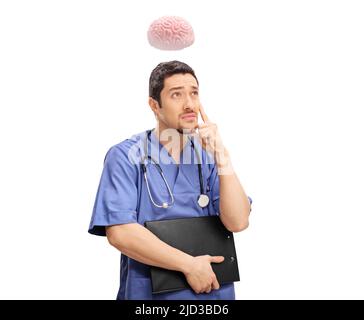 Junger Arzt hält eine Zwischenablage und denkt mit Gehirn über seinem Kopf isoliert auf weißem Hintergrund Stockfoto