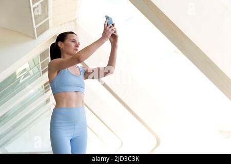 Attraktive sportliche Frau, die ein Selfie auf ihrem Smartphone macht. Stockfoto