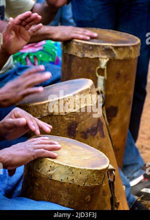 Perkussionisten spielen eine rudimentäre Atabake aus Leder und Holz während einer afro-brasilianischen Kulturveranstaltung Stockfoto