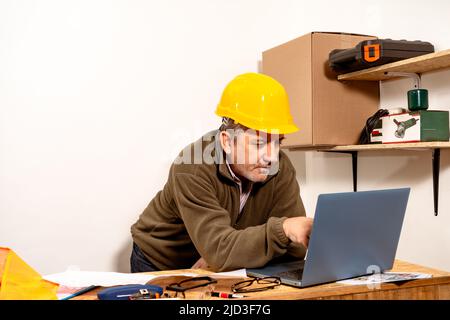Kaukasischer Techniker prüft Laptop im Büro. Konzept der Arbeitsorganisation. Stockfoto