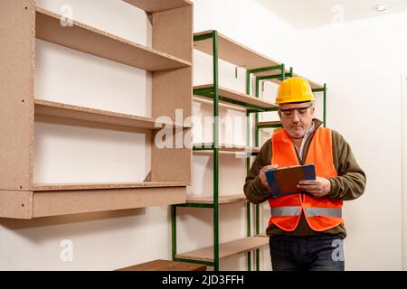 Kaukasischer Inspektor, der den Status und den Fortschritt der Arbeit im Arbeitsamt überprüft. Konzept der Arbeitsorganisation, Inspektion, Stockfoto