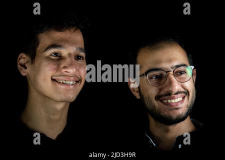 Porträt von 2 jungen Männern auf schwarzem Hintergrund. Hochwertige Fotos Stockfoto