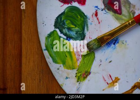 Draufsicht auf eine Malerpalette mit Farben und Pinsel Stockfoto