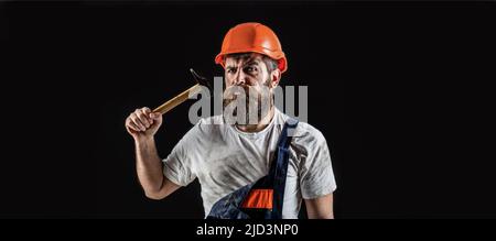 Bärtiger Arbeiter mit Bart, Helmbau, Schutzhelm. Hammer hämmert. Baumeister in Helm, Hammer, Handwerker, Baumeister in Hardhat Stockfoto