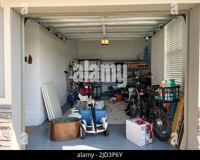 Orlando, FL USA - 3. März 2022: Eine unorganisierte Garage voller Sachen in einer Nachbarschaft. Stockfoto