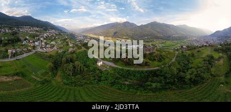 Luftaufnahme - Terrassenweingärten in den Hügeln des Valtellina in der Nähe von Denkmälern und alten mittelalterlichen Ruinen gepflanzt - Sondrio, Lombardei, Italien Stockfoto