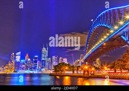 Bunte Lasershow in Australien - Vivid Sydney 2022 über den Hafen mit Bogen der Sydney Habour Brücke bei Nacht. Stockfoto