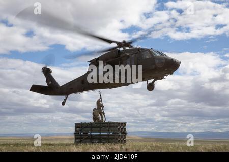 Soldaten des Bataillons 5., des Artillerieregiments 113., North Carolina National Guard, führen während des Western Strike 22 im Orchard Combat Training Center, Idaho, 14. Juni 2022 eine Schlingentraglasoperation durch. WESTERN Strike 22 ist eine exportierbare Kampftrainingsübung, die von der 65. Field Artillery Brigade geleitet wird, die Soldaten der Nationalgarde ähnlich wie in einem Kampftrainingszentrum unterbringt und die Bereitschaft und Letalität der teilnehmenden Einheit erhöhen soll. (USA Armeefoto von Sgt. Rebecca Call) Stockfoto