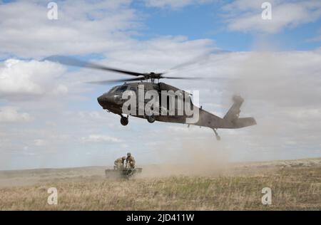 Soldaten des Bataillons 5., des Artillerieregiments 113., North Carolina National Guard, führen während des Western Strike 22 im Orchard Combat Training Center, Idaho, 14. Juni 2022 eine Schlingentraglasoperation durch. WESTERN Strike 22 ist eine exportierbare Kampftrainingsübung, die von der 65. Field Artillery Brigade geleitet wird, die Soldaten der Nationalgarde ähnlich wie in einem Kampftrainingszentrum unterbringt und die Bereitschaft und Letalität der teilnehmenden Einheit erhöhen soll. (USA Armeefoto von Sgt. Rebecca Call) Stockfoto