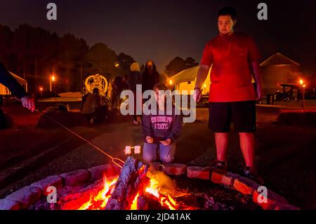 Die Menschen stoßen auf S’mores über ein Lagerfeuer am 25. September 2012 in Caledonia, Mississippi. S’mores sind ein beliebtes Lagerfeuer-Vergnügen. Stockfoto