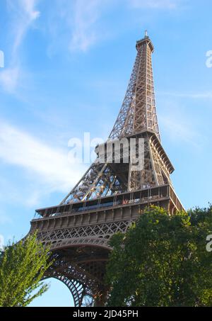 Eiffelturm von unten mit Bäumen und dem blauen Himmel im Hintergrund Stockfoto