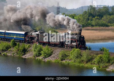 HELYULYA, RUSSLAND - 11. JUNI 2022: Zwei alte sowjetische Dampflokomotiven der L-Serie ziehen den touristischen Retro-Zug 'Ruskeala Express' Stockfoto