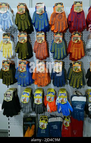 Bunte Arbeitshandschuhe, die an einer Theke eines Ladens verkauft werden. Branchenmesse. 17. November 2021. Kiew, Ukraine Stockfoto