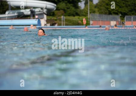 Weener, Deutschland. 18.. Juni 2022. Zahlreiche Personen schwimmen im Freibad 'Friesenbad', dank Fernwärme können Badegäste ab acht Uhr in den Pool eintreten. Die Wassertemperatur beträgt kontinuierlich 29 Grad. Quelle: Lars Klemmer/dpa/Alamy Live News Stockfoto