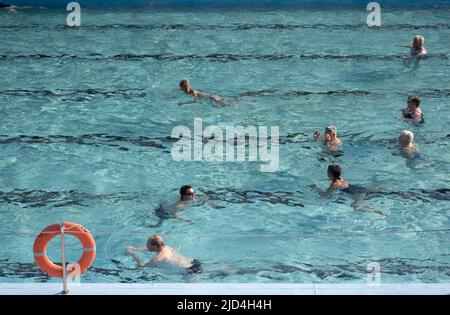 Weener, Deutschland. 18.. Juni 2022. Zahlreiche Personen schwimmen im Freibad 'Friesenbad', dank Fernwärme können Badegäste ab acht Uhr in den Pool eintreten. Die Wassertemperatur beträgt kontinuierlich 29 Grad. Quelle: Lars Klemmer/dpa/Alamy Live News Stockfoto