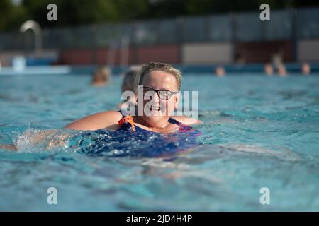 Weener, Deutschland. 18.. Juni 2022. Eine Frau schwimmt im Freischwimmbad Friesenbad, dank Fernwärme können Badegäste bereits um acht Uhr in den Pool eintreten. Die Wassertemperatur beträgt kontinuierlich 29 Grad. Quelle: Lars Klemmer/dpa/Alamy Live News Stockfoto