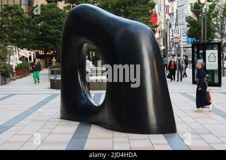 TOKIO, JAPAN - 9. Juni 2022: Straße und plaza von Roppongis Tokyo Midtown mit einer von Kan Yasuda entworfenen Skulptur. Stockfoto