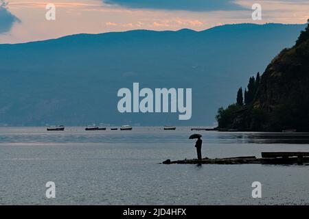 Ohrid, Nordmakedonien. 17.. Juni 2022. Ein Bürger steht am 17. Juni 2022 in Ohrid, Nordmakedonien, im Regen. Quelle: Tomislav Georgiev/Xinhua/Alamy Live News Stockfoto