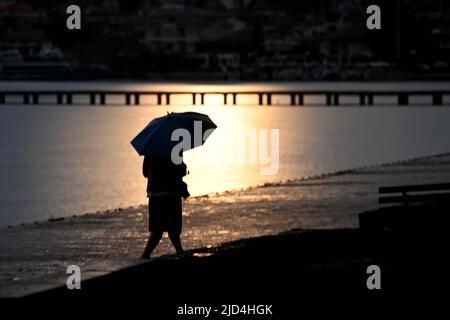 Ohrid, Nordmakedonien. 17.. Juni 2022. Ein Bürger spaziert am 17. Juni 2022 im Regen in Ohrid, Nordmakedonien. Quelle: Tomislav Georgiev/Xinhua/Alamy Live News Stockfoto