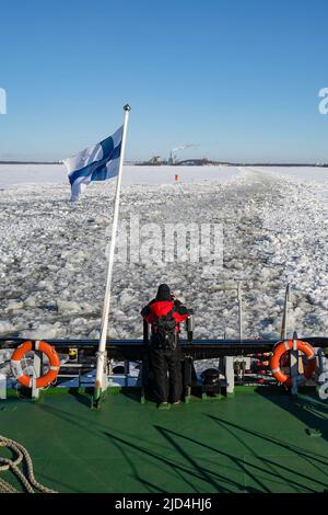 Rovaniemi, Finnland - 21.. März 2022: Ein Tourist am Heck des finnischen Eisbrechers Sampo fotografiert die Spuren des gebrochenen Eises, das er hinterlässt Stockfoto