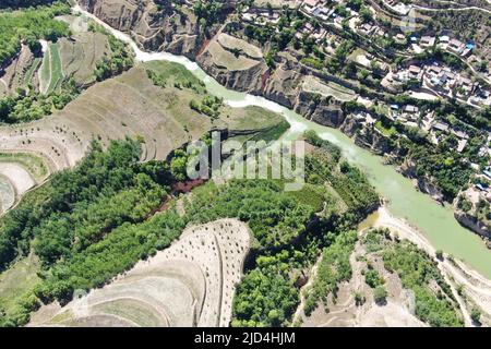 (220618) -- DINGXI, 18. Juni 2022 (Xinhua) -- Luftfoto zeigt grünen Hügel mit Bäumen, die von den Zwillingsbrüdern Xu Zhigang und Xu Zhiqiang im Dorf Zhangchuan im Bezirk Tongwei, nordwestlich der chinesischen Provinz Gansu, gepflanzt wurden, 15. Juni 2022. Xu Zhigang und sein Zwillingsbruder Xu Zhiqiang haben über 50 Jahre lang freiwillig Bäume auf kargen Hügeln auf dem Löss-Plateau gepflanzt. Mehr als 350 mu (etwa 23 Hektar) karges Land haben sich mit ihrer Pflanzung von Baumkeimlingen grün gemacht. Die Bemühungen der Brüder haben nicht nur dazu beigetragen, natürliche Schönheit zu schaffen, sondern auch die lokale ökologische Umwelt zu verbessern. (Xinhua/M Stockfoto