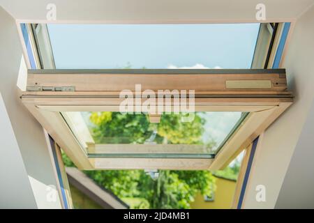 Nahaufnahme eines offenen Holzdachfensters. Brandneue Installation im Wohngebäude. Stockfoto