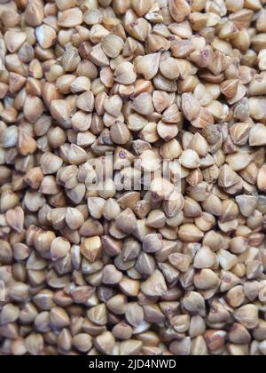 Organischer Buchweizen groats Makro Hintergrund. Geröstete, trockene Buchweizenkörner, Textur aus der Nähe. Vollkorn-Buchweizensamen für glutenfreie Ernährung. Stockfoto