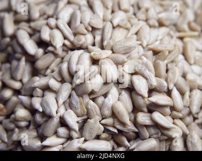 Viele geschälte Sonnenblumenkerne aus der Nähe. Haufen Sonnenblumenkerne, Vollformat. Stockfoto