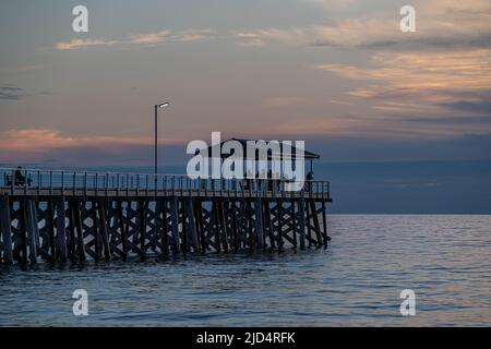 18. Juni 2022: Ein Pier in Adelaide, der bei Sonnenuntergang in Australien silhouettiert wurde Stockfoto