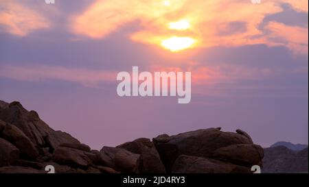 Spektakulärer Sonnenuntergang im Namibia Damaraland mit Bergkette im Hintergrund. Namibia Reiseziel. Gesehen auf der Fahrt. Stockfoto