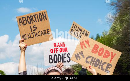 Demonstranten, die Zeichen halten Abtreibung ist Gesundheit, Mein Körper Meine Wahl, Verbote unseren Körper, Menschenrechte. Menschen mit Plakaten bei der Protestdemonstration. Stockfoto