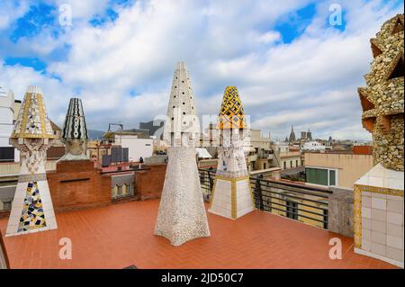 Barcelona, Spanien. Die farbenfrohen Mosaikschornsteine aus zerbrochenen Keramikfliesen auf dem Dach des Palau Güell, die vom katalanischen Architekten Antoni Gaudi entworfen wurden Stockfoto