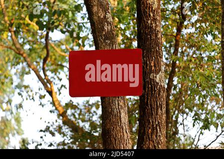 Am Baum wurde tagsüber im Freien ein leeres rotes Schild vernagt Stockfoto