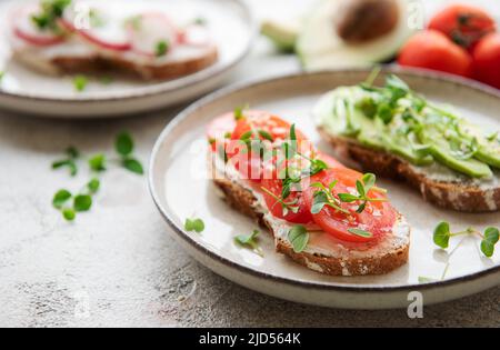 Verschiedene Sandwiches mit Gemüse und Microgreens. Gesunde Ernährung Stockfoto