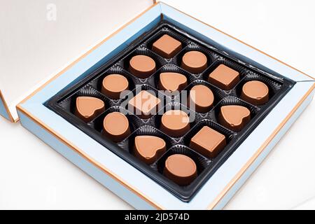 Eine Schachtel Pralinen in verschiedenen Formen und Geschmacksrichtungen. Das Konzept eines ersten Termins und Süßwaren Süßigkeiten Stockfoto
