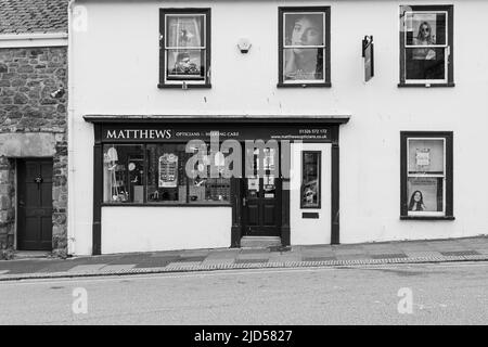 Einzelhandelsgeschäfte (Matthews Optician) in der Coinagehall Street, Helston, Cornwall, England Stockfoto