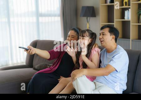 Glückliche asiatische Familie mit Vater, Mutter und Tochter genießen Wochenendaktivitäten verbringen mehr Zeit zu Hause und damit wahrscheinlich mehr Zeit vor dem Stockfoto