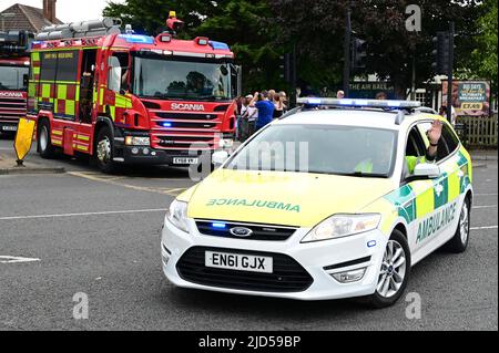 Horley, Surrey, Großbritannien-Juni 18 2022: Ein Krankenwagen und ein Feuerwehrauto fahren in Horley, Surrey, über eine Rechtskurve. Stockfoto