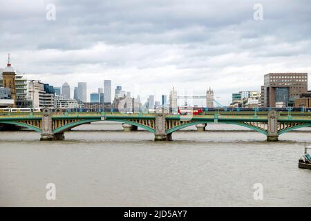 Roter Londoner Doppeldeckerbus über die Southwark Bridge und Blick auf die Themse mit Blick auf die Tower Bridge City of London UK im Jahr 2022 KATHY DEWITT Stockfoto