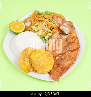 Gebratener Fisch - Tilapia mit weißem Reis und gebratenen Kochbananen und Salat. Stockfoto