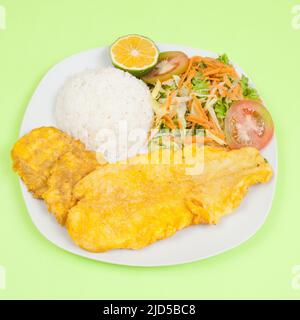 Gebratener Fisch; leckeres gebratenes Seebarschfilet mit Reis und Salat. Stockfoto