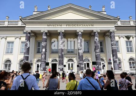 Kassel, Deutschland. 18.. Juni 2022. Vor dem Fridericianum stehen nach der Eröffnung die Besucher der documenta fünfzehn, deren Säulen vom rumänischen Künstler Dan Perjovschi mit schwarzer Farbe bemalt und mit weißen Symbolen und Schildern zu Themen wie Frieden, Solidarität oder Nachhaltigkeit beschriftet wurden. Die Weltkunstausstellung wurde am Samstag (18,06.) in Anwesenheit des Bundespräsidenten eröffnet und dauert bis zum 25. September. Quelle: Uwe Zucchi/dpa/Alamy Live News Stockfoto