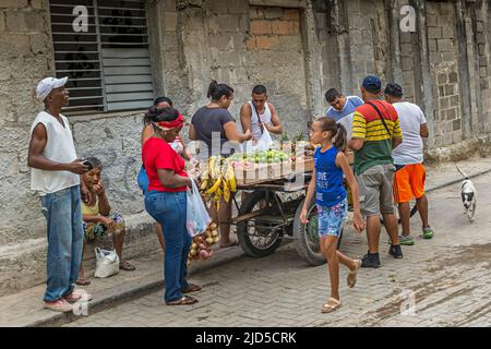 Ein Straßenverkäufer in Havanna, umgeben von Kunden, verkauft Obst und Gemüse in der Altstadt von Havanna, Kuba Stockfoto