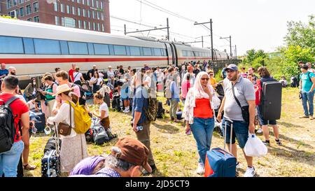 Hertogenbosch, Niederlande. 18 Juni 2022. Passagiere, die in der heißen Sonne zwischen den Bahngleisen warteten, neben dem gebrochenen internationalen Zug (ICE 153), der kurz nach dem Hertogenbosch des NS-Bahnhofs zum Stillstand kam. Kredit: Steppeland/Alamy Live Nachrichten. Stockfoto