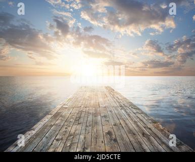 Langer Pier, der in den See führt, Sonnenaufgang, Himmel und Wolken auf dem See Stockfoto