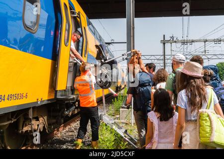 Hertogenbosch, Niederlande. 18 Juni 2022. Ein Kinderwagen wird von den Fahrgästen über eine befestigte Leiter in den Ersatzzug gehoben. Kredit: Steppeland/Alamy Live Nachrichten. Stockfoto