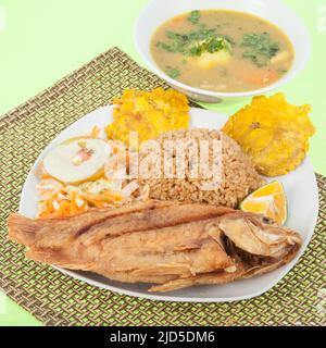 Gebratener Fisch - Tilapia mit Kokosreis und gebratenen Bananen, Salat und Suppe. Stockfoto