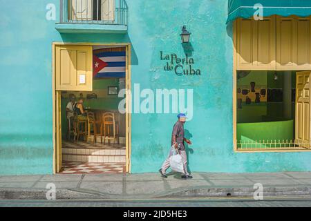 Ein Kubaner geht an einer hellgrün bemalten Bar in Camagüey, Kuba, vorbei Stockfoto