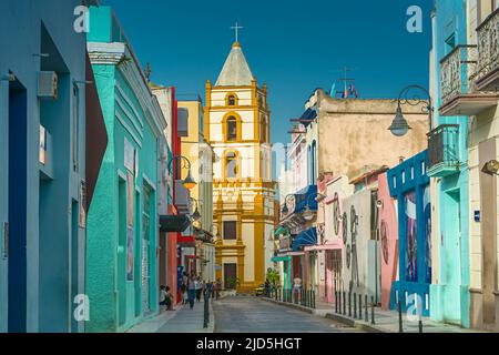 Die bunten Häuser der Calle Ignacio Agramonte mit dem Glockenturm der Kirche Iglesia de Nuestra Senora de la Soledad im Hintergrund Stockfoto